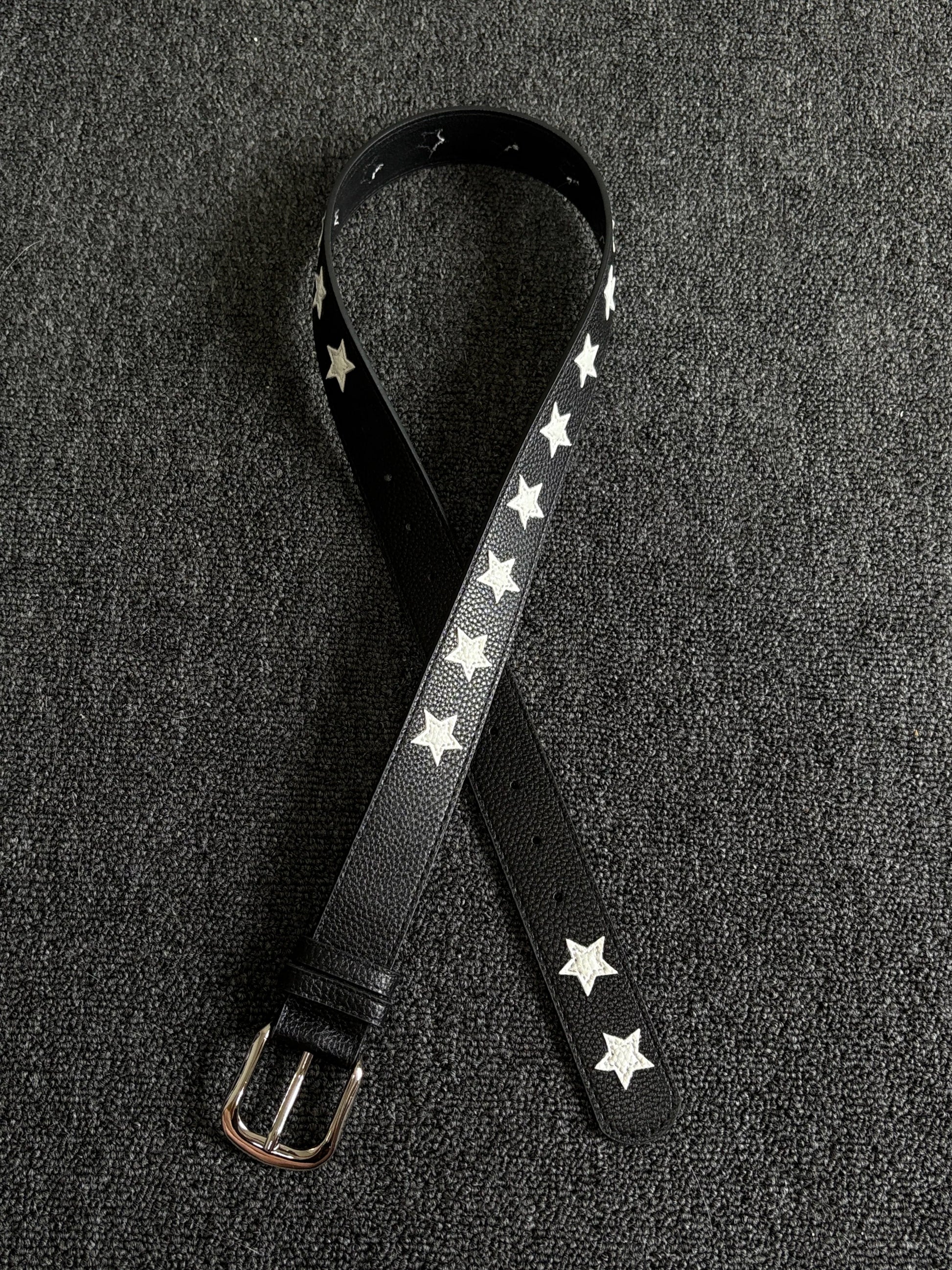 Black pebbled belt with white star inlays and a silver pin buckle