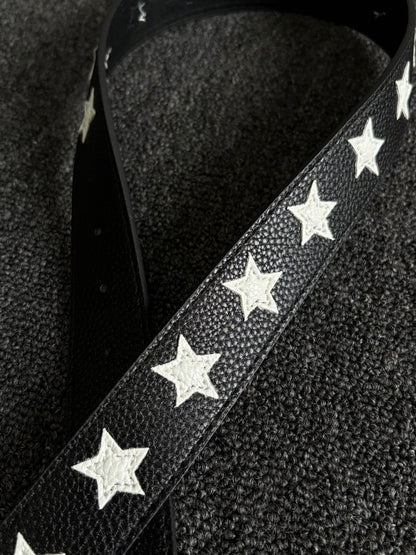 Black pebbled belt with white star inlays and a silver pin buckle