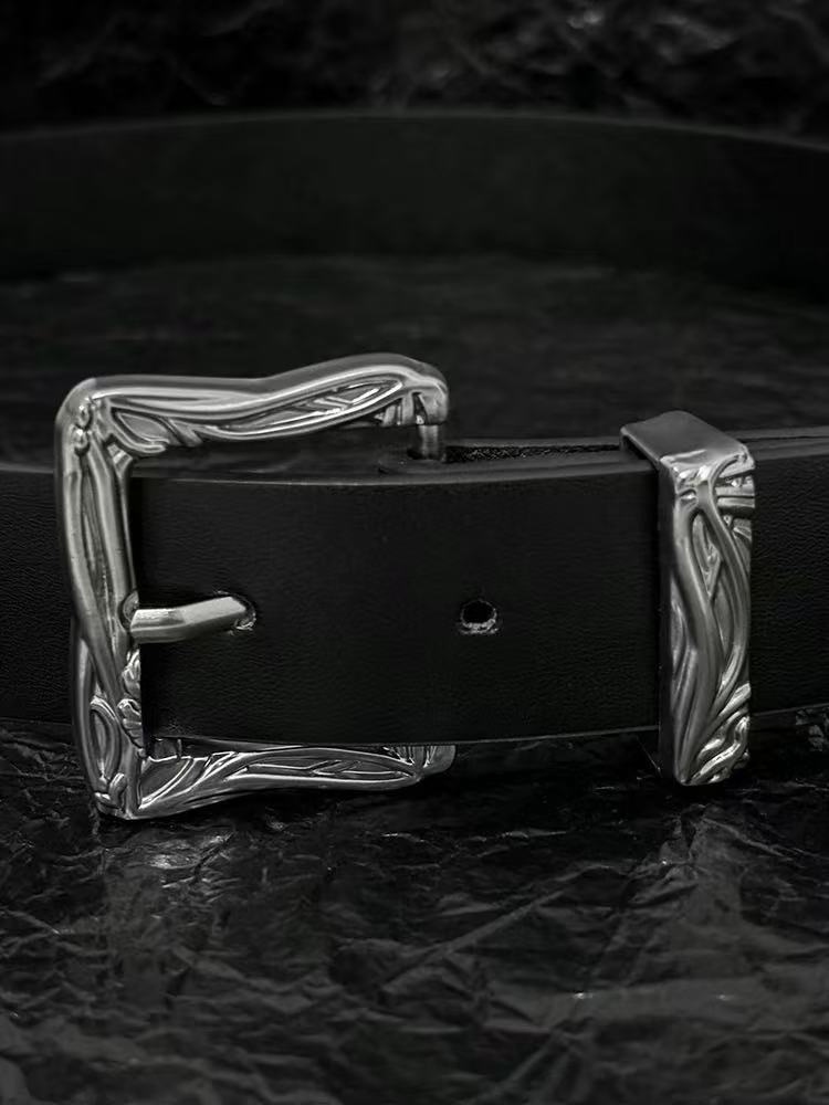 Black belt with carved western buckle and silver broken-sword tip