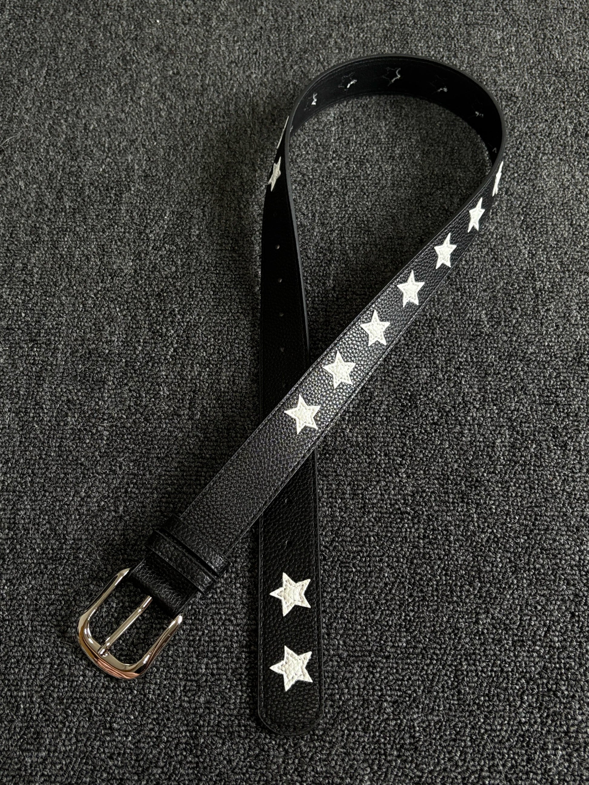 Black pebbled belt with white star inlays and a silver pin buckle